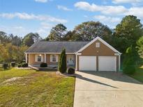 Ranch style home with two-car garage and well-manicured lawn at 390 Highpoint Xing, Powder Springs, GA 30127