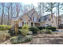 Charming two-story home with beige siding, red shutters, a well-maintained lawn, and mature trees at 54 Etham Pl, Douglasville, GA 30134
