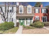 Inviting townhome exterior featuring a green door and landscaping at 1304 Wedgewood Ct, Atlanta, GA 30350