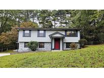 Two-story house with gray siding, red door, and stone accents at 1906 Young Rd, Lithonia, GA 30058