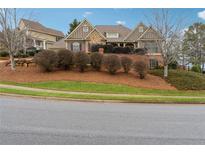 Charming two-story home featuring stone accents, lush landscaping, and a well-maintained yard at 100 Pine Sandy Bank Dr, Canton, GA 30114