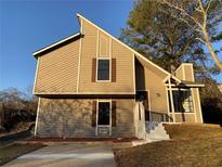 Charming home featuring unique architectural details, a well-manicured lawn, and a welcoming entrance at 1126 Mainstreet Valley Dr, Stone Mountain, GA 30088