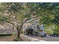 Elegant condo building exterior with a covered entrance and lush landscaping at 1 Biscayne Nw Dr # 809, Atlanta, GA 30309