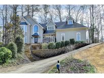 Charming two-story stucco home with a well-manicured lawn and mature trees at 976 Forest Pond Cir, Marietta, GA 30068