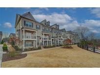 Charming townhomes with brick facade, white trim, and small private balconies create an inviting curb appeal at 2203 Fullers Aly, Kennesaw, GA 30144