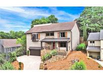 Charming two-story home with landscaped yard, stone accents, and a welcoming front porch at 10195 Kinross Rd, Roswell, GA 30076