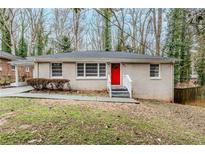 Charming single-story home featuring a brick facade and a vibrant red front door at 2096 Snow Sw Rd, Atlanta, GA 30311