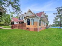 House exterior showcasing a red roof, brick accents, and a spacious lawn at 300 Jonesboro Rd, Mcdonough, GA 30253