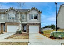 Charming two-story townhome with brick accents, single car garage, and well-maintained landscaping at 5831 Taka Ln, Lithonia, GA 30038