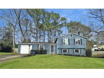 Charming two-story home with blue siding, a well-manicured lawn, and attached garage at 850 Waterbrook Ct, Roswell, GA 30076