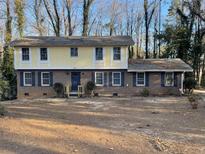 Two-story brick house with yellow accents, featuring a large front yard and mature trees at 1600 Whisperwood Trl, Stone Mountain, GA 30088
