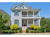 Charming two-story home featuring a double porch, red front door, and beautifully landscaped front yard at 7460 Cordery Rd, Cumming, GA 30040