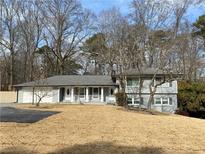 Charming gray split-level home featuring a well-manicured lawn and front porch at 1888 Peeler Rd, Atlanta, GA 30338