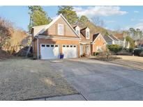 Brick home with two-car garage and landscaped lawn at 603 Redwood Ln, Canton, GA 30114