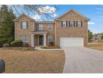 Charming brick two-story home featuring a well-manicured front yard and an attached two-car garage at 1260 Sailwind Ct, Buford, GA 30518