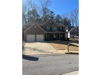 Charming brick two-story home featuring a two-car garage and well-maintained front yard at 2208 Ginger Lake Ne Dr, Conyers, GA 30013