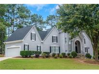 Gray two-story house with a gray roof, landscaping, and a two-car garage at 1456 Reagan Nw Cir, Conyers, GA 30012