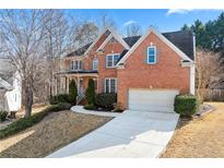 Charming two-story brick home with attached garage and beautifully landscaped front yard at 1302 Turtlebrook Ln, Lawrenceville, GA 30043