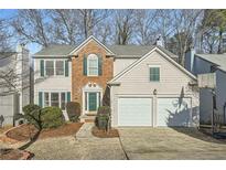 Charming two-story home with a two-car garage and mature landscaping at 10965 Glenbarr Dr, Johns Creek, GA 30097