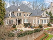 Elegant brick home featuring manicured landscaping, a stone patio, and a charming entrance at 110 Mattison Cv, Atlanta, GA 30319