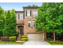 Charming brick home with a two-car garage, beautiful landscaping, and inviting front entrance at 938 Canterbury Ln, Atlanta, GA 30324