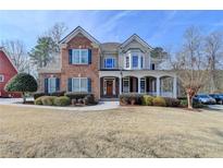 Charming brick home featuring a welcoming front porch and beautifully landscaped front yard at 1683 Wheatstone Dr, Grayson, GA 30017
