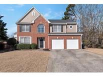 Charming two-story home featuring brick and siding, a two-car garage, and a well-manicured front lawn at 1348 Rolling Stream Way, Lawrenceville, GA 30043