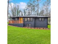 Beautifully renovated single-story home with striking black exterior and well-manicured lawn at 3661 W Potomac Dr, East Point, GA 30344