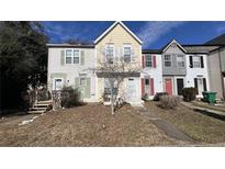 Charming townhome featuring a well-maintained lawn, colorful siding, and a welcoming entrance at 497 Prince Of Wales, Stone Mountain, GA 30083