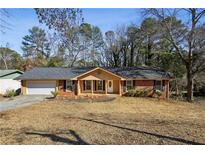 Charming one story home with a red brick facade, a garage, and lawn at 992 Yemassee Trl, Stone Mountain, GA 30083