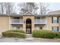 Two-story condo building with stucco exterior, stone accents, and private balconies at 3140 Seven Pines Ct # 202, Atlanta, GA 30339