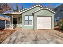 Charming home features light green siding and a one car garage at 4676 Cedar Park Trl, Stone Mountain, GA 30083