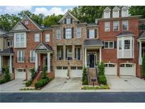 Charming townhome showcasing brick facade, private garages, and well-maintained landscaping, creating a welcoming curb appeal at 5964 Reddington Way, Sandy Springs, GA 30328