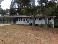 Charming single-story home with a covered carport, American flag, and well-maintained yard at 5250 Hollyhock Rd, Douglasville, GA 30135