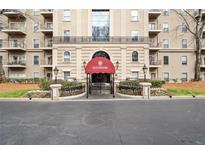 Elegant building entrance with a red awning and manicured landscaping at 2865 Lenox Ne Rd # 410, Atlanta, GA 30324