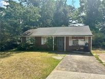 Cozy brick home features a classic design and a traditional front yard at 5278 Madison St, Forest Park, GA 30297