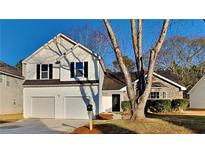 Charming two-story home boasts a manicured lawn, two-car garage, and inviting stone accents at 2822 Ward Lake Way, Ellenwood, GA 30294