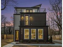 Modern three-story home with balconies and a combination of wood and white siding at 662 S Grand Nw Ave, Atlanta, GA 30318