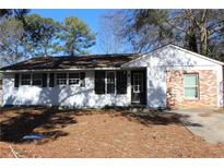 Charming single-story home with a painted white brick and dark shutters, offering timeless curb appeal at 6441 Holiday Blvd, Forest Park, GA 30297