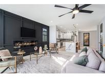 Bright open-concept living room features a modern fireplace and seamless flow into the kitchen at 676 S Grand Nw Ave, Atlanta, GA 30318