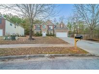 Charming two-story brick home with well-maintained landscaping and a welcoming front porch at 3860 Busby Mill Ct, Ellenwood, GA 30294