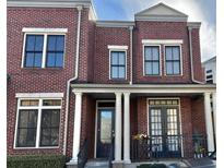Charming brick townhouse featuring black-framed windows and a welcoming front porch with columns at 4666 Magnolia Commons, Dunwoody, GA 30338