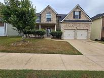 Charming two-story brick home with a well-maintained lawn and a two-car garage at 7214 Bedrock Cir, Lithonia, GA 30038