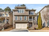 Inviting two-story home with a neutral color palette, a two-car garage, and a brick staircase leading to the front porch at 10 Clarke Hill St, Decatur, GA 30030