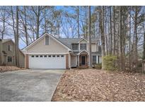 Charming two-story home with brick accents and a two-car garage nestled amongst mature trees at 3214 Country Walk Dr, Powder Springs, GA 30127