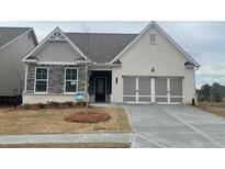 Charming single-Gathering home featuring a brick and stone facade, complemented by a well-manicured lawn at 822 Kestrel Dr, Loganville, GA 30052