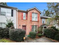 Charming townhome with brick facade, colorful shutters, and well-maintained landscaping at 338 Saratoga Pl, Riverdale, GA 30296