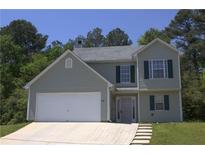 Charming two-story home with gray siding, dark shutters, attached two-car garage, and well-manicured landscaping at 5627 Isleworth Ct, Atlanta, GA 30349