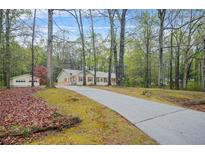 Ranch style home with red shutters is surrounded by mature trees at 125 Bridget Dr, Hampton, GA 30228