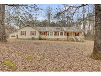 Inviting single-story home with red shutters and a charming front porch at 125 Bridget Dr, Hampton, GA 30228